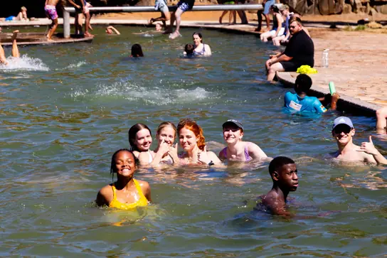 Campers smiling and swimming in the dam