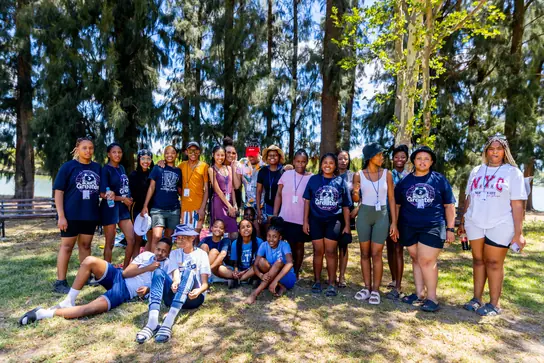 A big group photo of campers under the trees